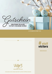 Blaue Ostereier liegen auf einem blauen Geschenk, im Hintergrund zarte Frühlingszweige.