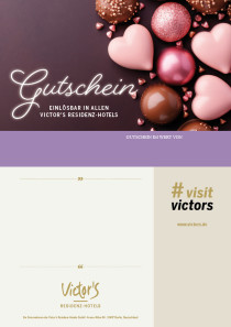 Große und kleine rosafarbene Herzen und Schokladenkugeln liegen auf einem dunkleren Hintergrund.