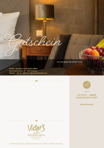 Ein Zimmer in Brauntönen. Eine Tischlampe taucht ein einladendes Bett und einen Sessel in gemütliches Licht.