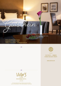 Ein stilvolles Zimmer mit Bett und Sitzmöbeln. Im Vordergrund sthet ein Tisch mit Blumenvase und Obstteller.