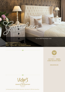 Stilvoll drohnt ein weißes Bett mit hohem Kopfteil zwischen zwei Nachttischen. Die edle braun-goldene Tapete verleiht dem Zimmer Eleganz.