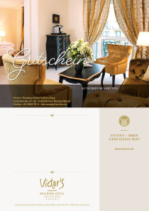 Eine  Suite mit Sofa, Stühlen, Couchtisch. Darauf steht ein großer Blumenstrauß. Im Hintergrund ist ein Durchgang zum nächsten Zimmer und ein Bett.