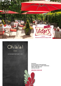 Einladend eingedeckte Tische stehen auf der Terrasse, umgebend von hohen Bäumen. Geöffnete Sonnenschirme bieten Schatten.