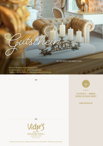 Ein elegantes Zimmerdetail in den Farben Gold und Beige zeiigt einen bequemen Sesseln vor einem Tisch mit Kerzen.