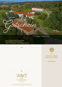 Die weite Landschaft um das Hotel herum ist zu sehen. Das Hotelgelände ist eingebettet in grüner Natur.