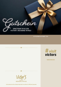Ein edel eingepacktes Geschenk mit goldener Schleife liegt auf einen dunklen Untergrund.
